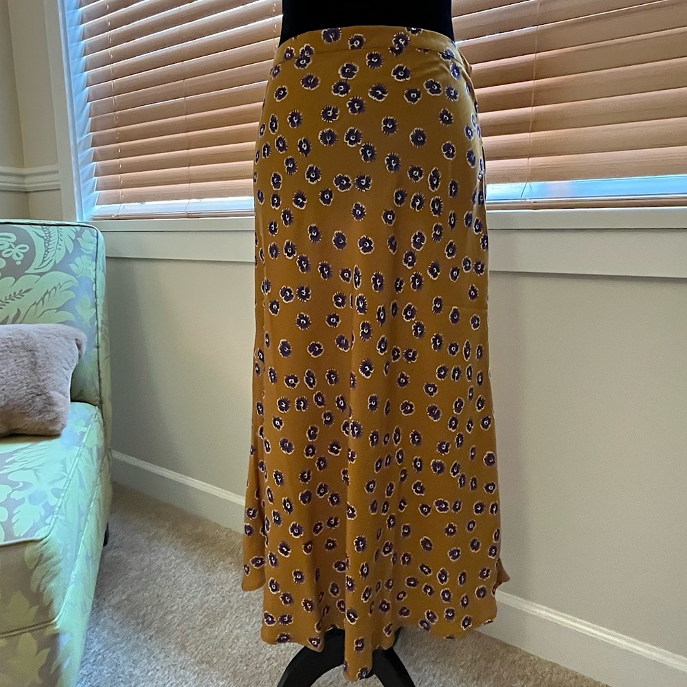 Midi length skirt, gold background with purple and white flower pattern.
